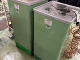 deux machines à laver vertes dans une pièce avec un rideau noir