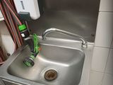un lavabo dans des toilettes publiques, muni d'un tuyau