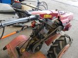 a red tractor with a small engine parked in a garage