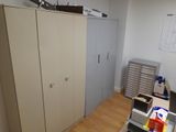 a closet in the corner of a room with a lot of clutter on the floor