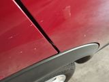 a close up of a red car with the door handle missing