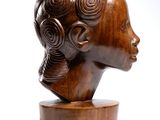 wooden sculpture of a woman ' s head on a wooden stand