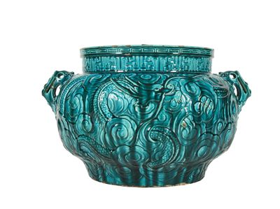 un grand vase vert muni d'un couvercle, sur fond blanc
