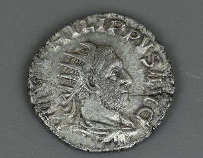 Gros plan sur une pièce de monnaie portant le visage d'un homme