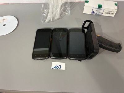 Plusieurs téléphones portables sont posés sur une table à côté d'une arme à feu