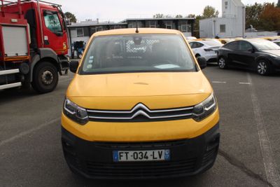 a yellow car parked in a parking lot next to a firetruck