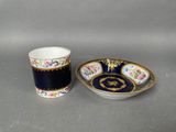 a cup and saucer are sitting on a table next to each other