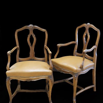 paire de chaises en bois sculpté avec des assises rembourrées de cuir