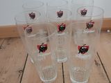 four glasses with a ladybug on them sitting on a wooden floor