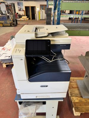 une imprimante posée sur une palette dans un entrepôt