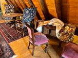 a room with a bed, chair, table, and rug in it