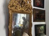 a statue of a woman sitting on a table in front of a mirror