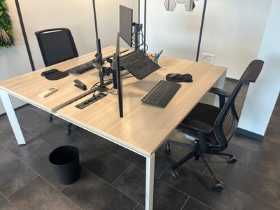 un bureau sur lequel se trouvent un ordinateur portable, un clavier, une souris et un écran