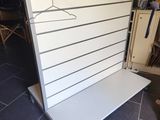 un gros plan sur un mur blanc sur lequel est accrochée une étagère