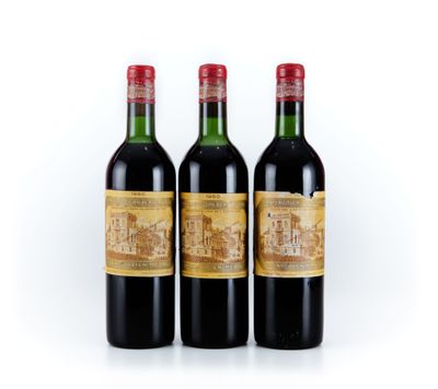 trois bouteilles de vin rouge posées l'une à côté de l'autre sur une surface blanche