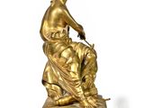 an image of a gold statue of a woman sitting on top of a table