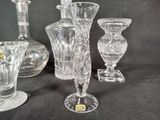 many glass vases sitting on a table with a black background