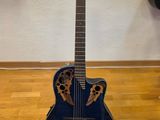 une guitare acoustique posée sur un parquet en bois massif