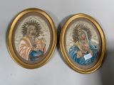 deux tableaux représentant Jésus et Marie, dans des cadres dorés, accrochés à un mur blanc