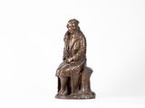 statue en bronze représentant un homme assis sur un banc avec un chien