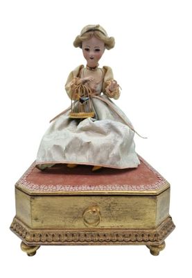 une figurine représentant une femme assise sur une boîte