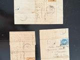 three pieces of old paper with stamps on them on a black surface