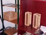 a red book shelf with boxes on it in a room