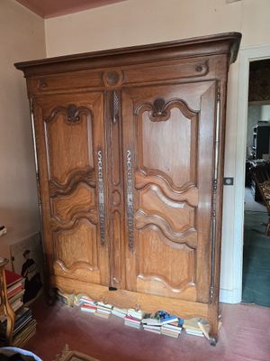 une grande armoire en bois dans le coin d'une pièce