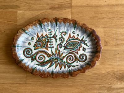 une assiette décorative posée sur une table en bois, avec un parquet