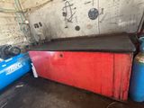 une boîte rouge avec un couvercle noir et un réservoir bleu