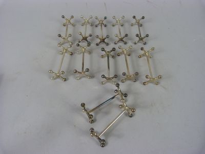 de nombreux objets métalliques de toutes sortes posés sur une surface blanche