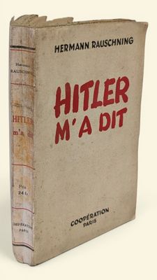 un vieux livre portant des inscriptions rouges, posé sur une surface blanche
