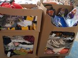 two cardboard boxes with clothes in them on the floor
