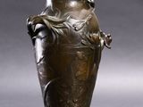 un vase en bronze posé sur une table