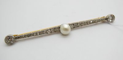un gros plan sur une broche ornée d'une perle blanche et de diamants