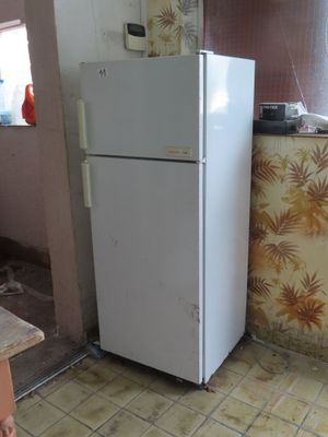 a white refrigerator in the corner of a kitchen