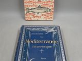 un livre sur lequel figure un poisson, à côté d'un autre livre posé sur une table