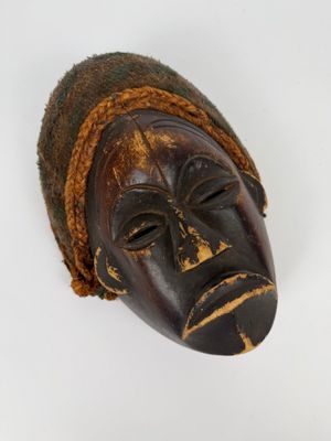un vieux masque en bois sur fond blanc, avec un fond blanc