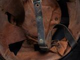 an old helmet with a leather strap is sitting on a table