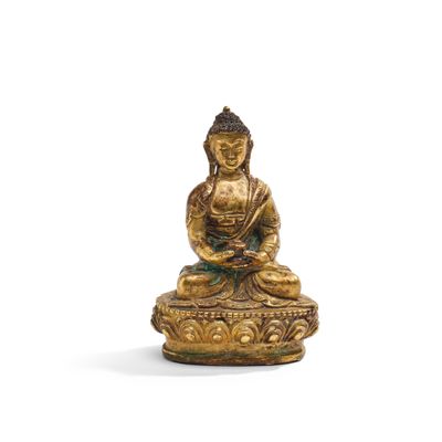 une statue en or représentant une personne assise sur un lotus