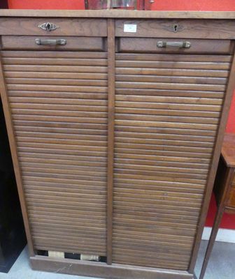 une armoire surmontée de volets, dans une pièce