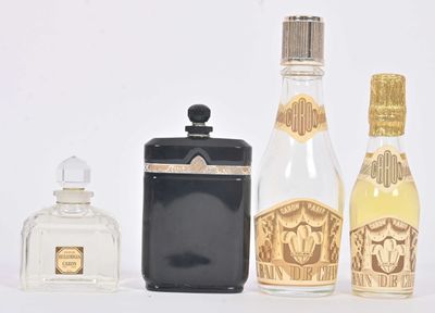 Plusieurs flacons de parfum sont alignés sur une surface blanche