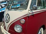 un minibus Volkswagen rouge et blanc garé sur un parking