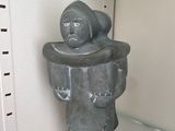 a statue of a man that is sitting on a shelf