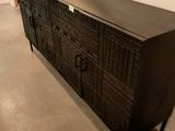 une commode noire surmontée d'un miroir