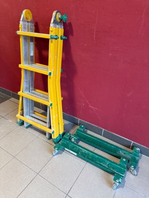 deux échelles posées contre un mur rouge