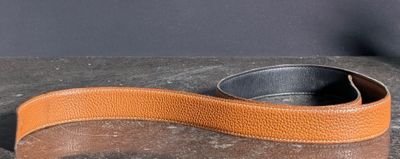 une ceinture en cuir marron munie d'une boucle en métal