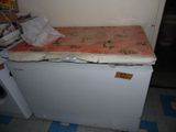 a mattress on top of a small refrigerator in a kitchen