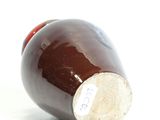 a brown bottle with a cork stopper sitting on a white surface