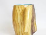 a close up of a wooden cup on a white surface